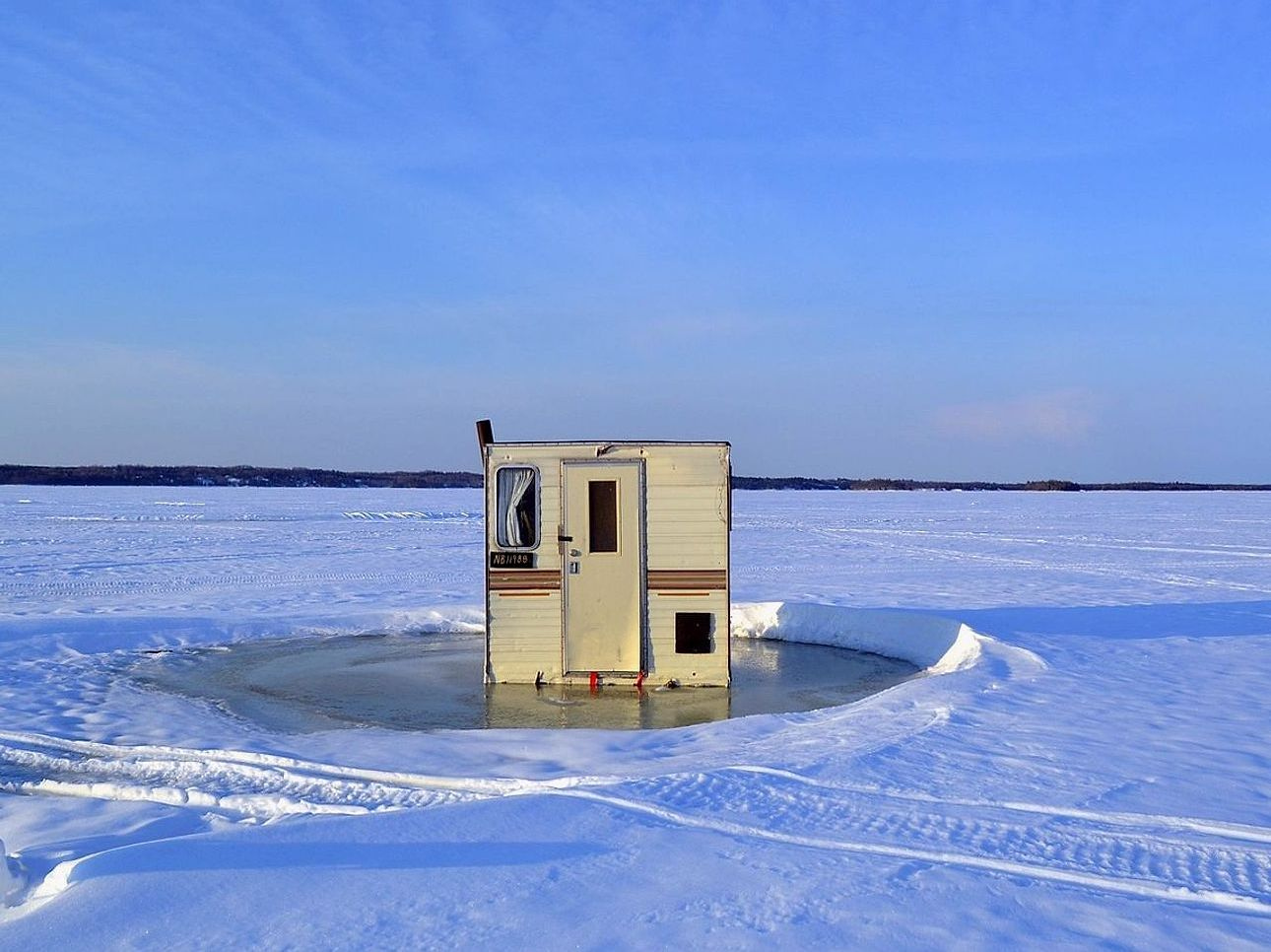 Un lago bajo el hielo al amanecer, antes de que salga el sol